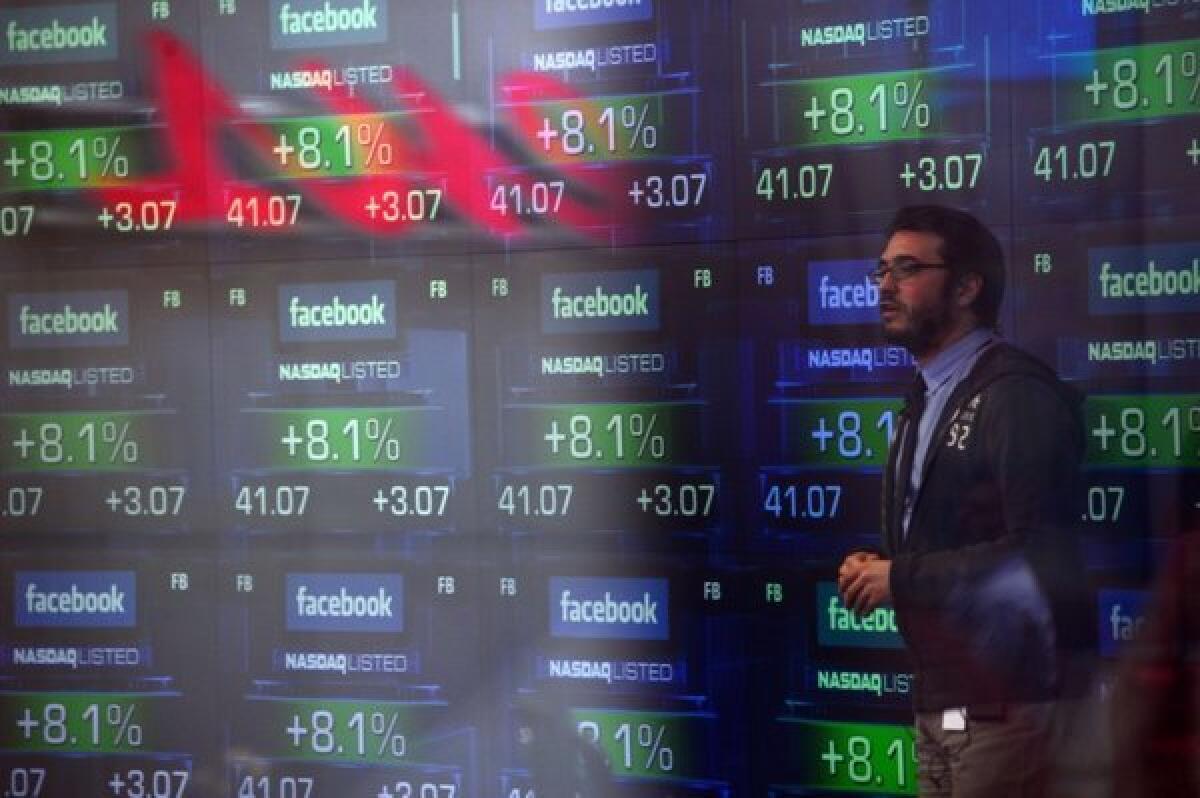A television anchor stands in front of screens showing the start of trading in Facebook shares on May 18, 2012. Shares were up $1.69, or 4%, to $49.01 on Tuesday. They hit an all-time high of $49.66 earlier in the day.