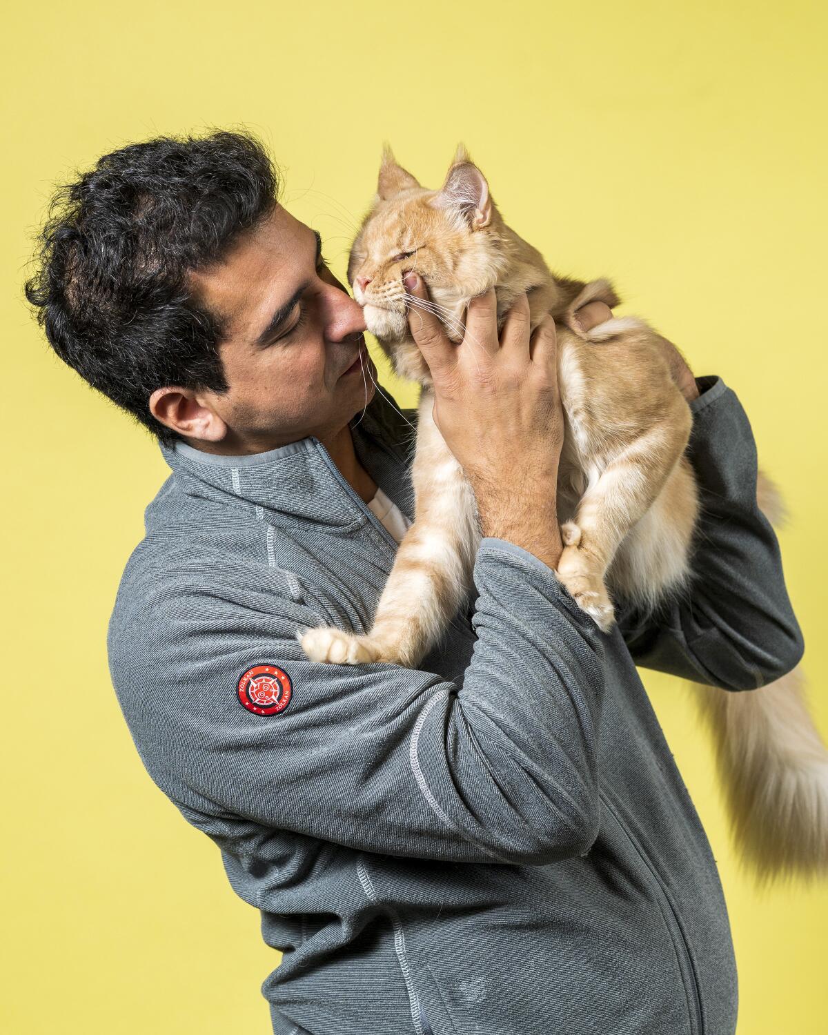 Mariano Cane holds his Maine Coon named Evsei.