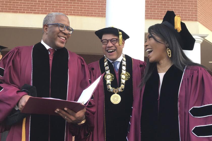 Robert F. Smith, left, laughs with David Thomas, center, and actress Angela Bassett at Morehouse College on Sunday, May 19, 2019, in Atlanta. Smith, a billionaire technology investor and philanthropist, said he will provide grants to wipe out the student debt of the entire graduating class at Morehouse College - an estimated $40 million. Smith, this year's commencement speaker, made the announcement Sunday morning while addressing nearly 400 graduating seniors of the all-male historically black college in Atlanta. (Bo Emerson/Atlanta Journal-Constitution via AP)