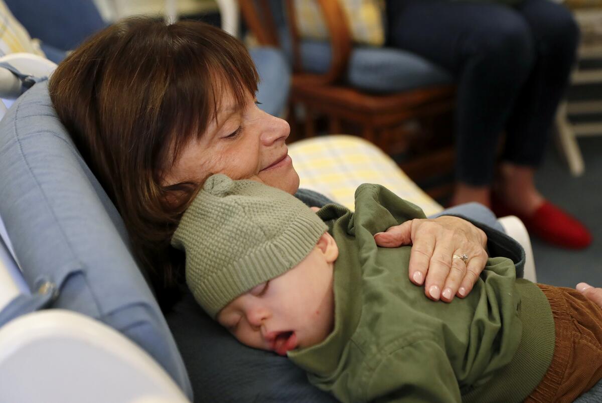 Volunteer "holder" Susan Silvia, rocks an infant to sleep at the early intervention program in Laguna Beach on Wednesday.