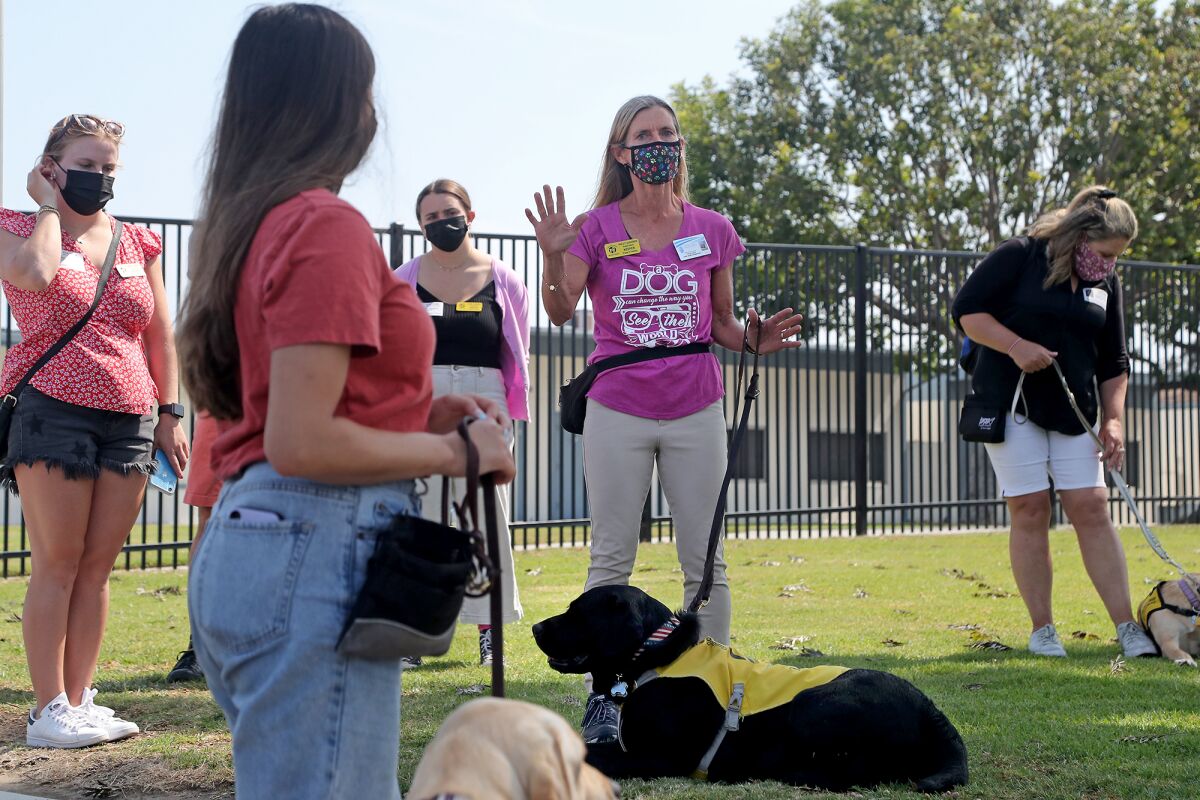 Fourth-grade teacher Holly Sjogren, center, speaks to Guide Dogs of America handlers.