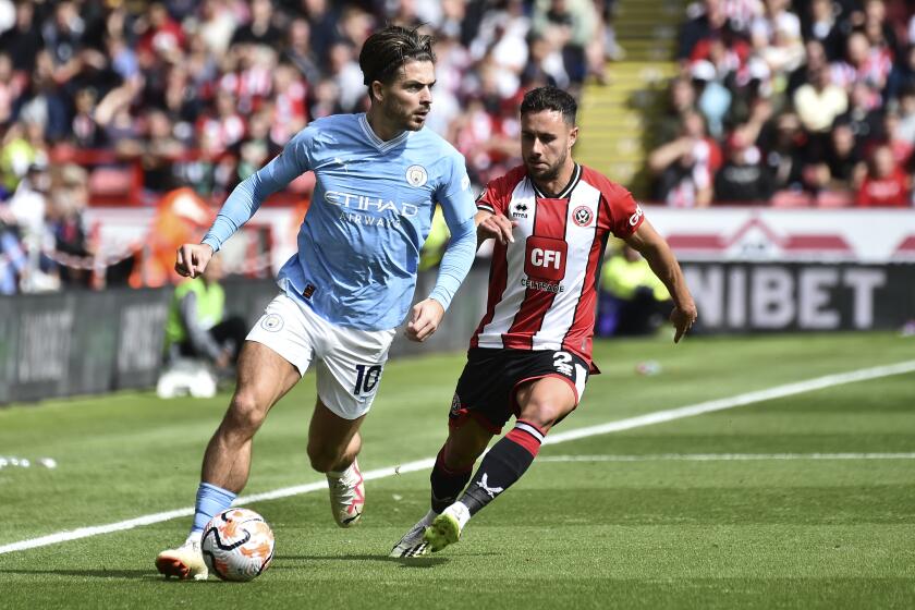 Manchester City's Jack Grealish, left, challenges for the ball with Sheffield United's George Baldock during the English Premier League soccer match between Sheffield United and Manchester City at Bramall Lane in Sheffield, England, Sunday, Aug. 27, 2023. (AP Photo/Rui Vieira)