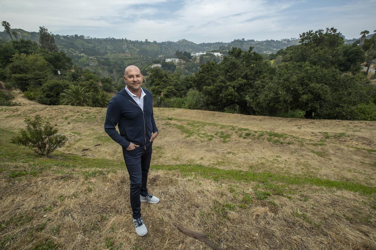 A man stands on a grassy hilltop