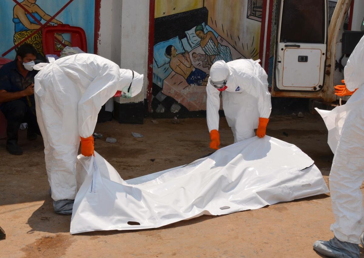 Liberian Red Cross workers collect the body of an Ebola victim in Monrovia on Sept. 12.