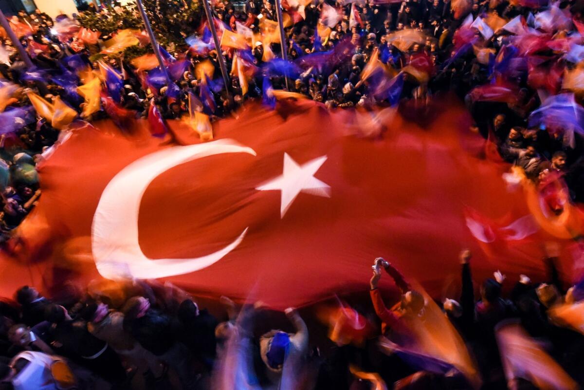 Supporters of Turkey's ruling Justice and Development Party wave a giant Turkish flag as they celebrate the results of the country's general election on Sunday in Istanbul.