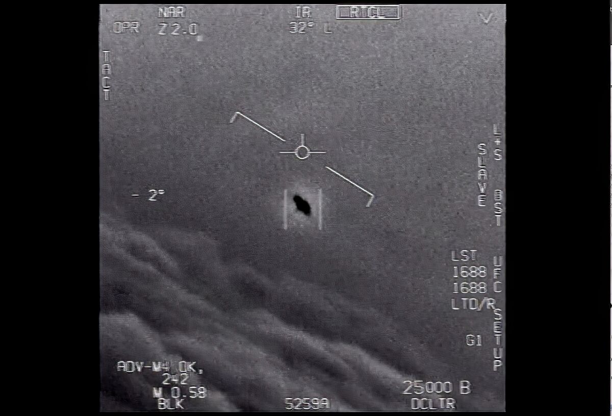 A black-and-white image shows a black dot above clouds.