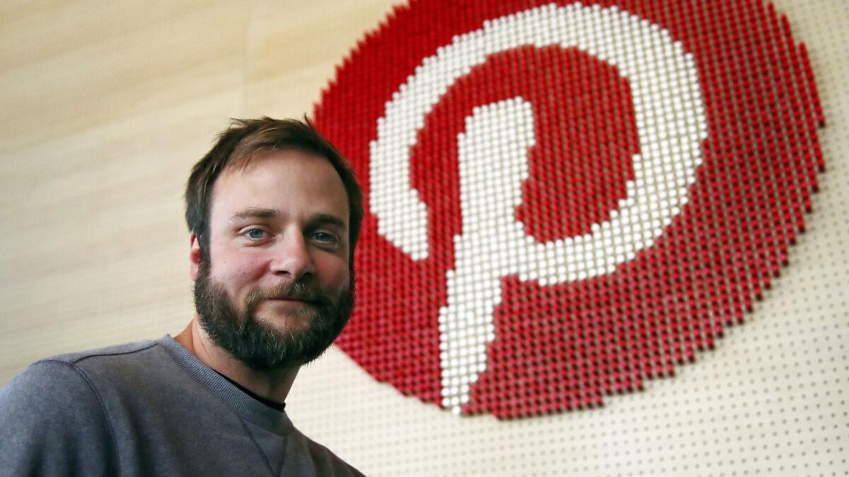 Evan Sharp, Pinterest co-founder and chief product officer, poses beside a wall of pegs symbolizing the company logo at its headquarters in San Francisco.