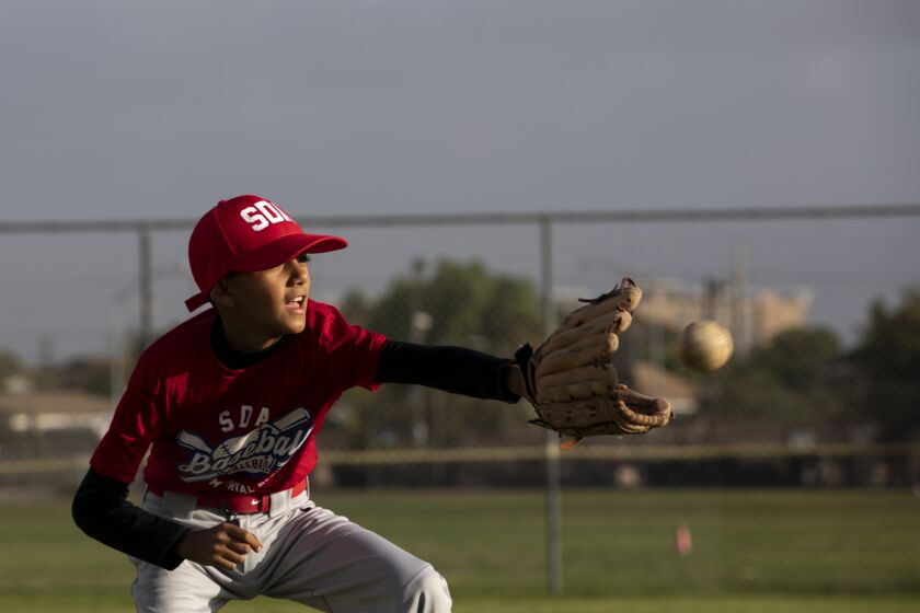 San Diego, CA - October 11: Pablo Dutra, 10, prepares to catch a ball during baseball practice at Memorial Park in Logan Heights on Monday, Oct. 11, 2021 in San Diego, CA. The snack shack at Memorial Park hasn't had running water in more than three years says Maria Pelayo, president of the San Diego American Little League. She and other parents have asked the city numerous times to help reconnect the water to the snack shack so they can sell items like nachos and hot dogs. The snack shack provides funding to the league and right now they're only able to sell packaged snacks like chips and candy. The park also has issues with people defecating around the snack shack and with having only one working light that faces the parking lot versus the field so practice ends earlier. (Ana Ramirez / The San Diego Union-Tribune)