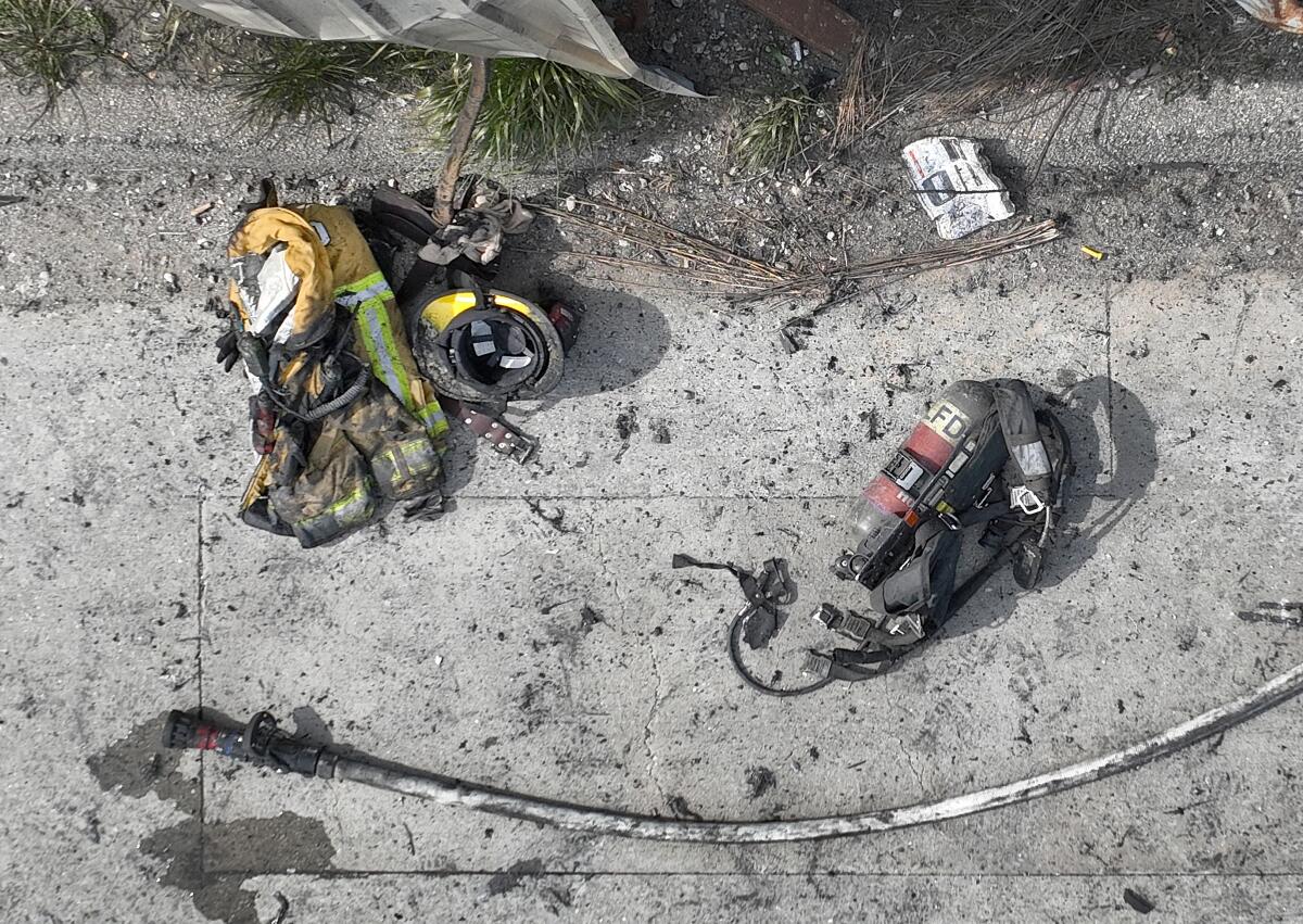 A scorched Los Angeles Fire Dept. firefighters' helmet, protective jacket, hose, oxygen backpack and radio.