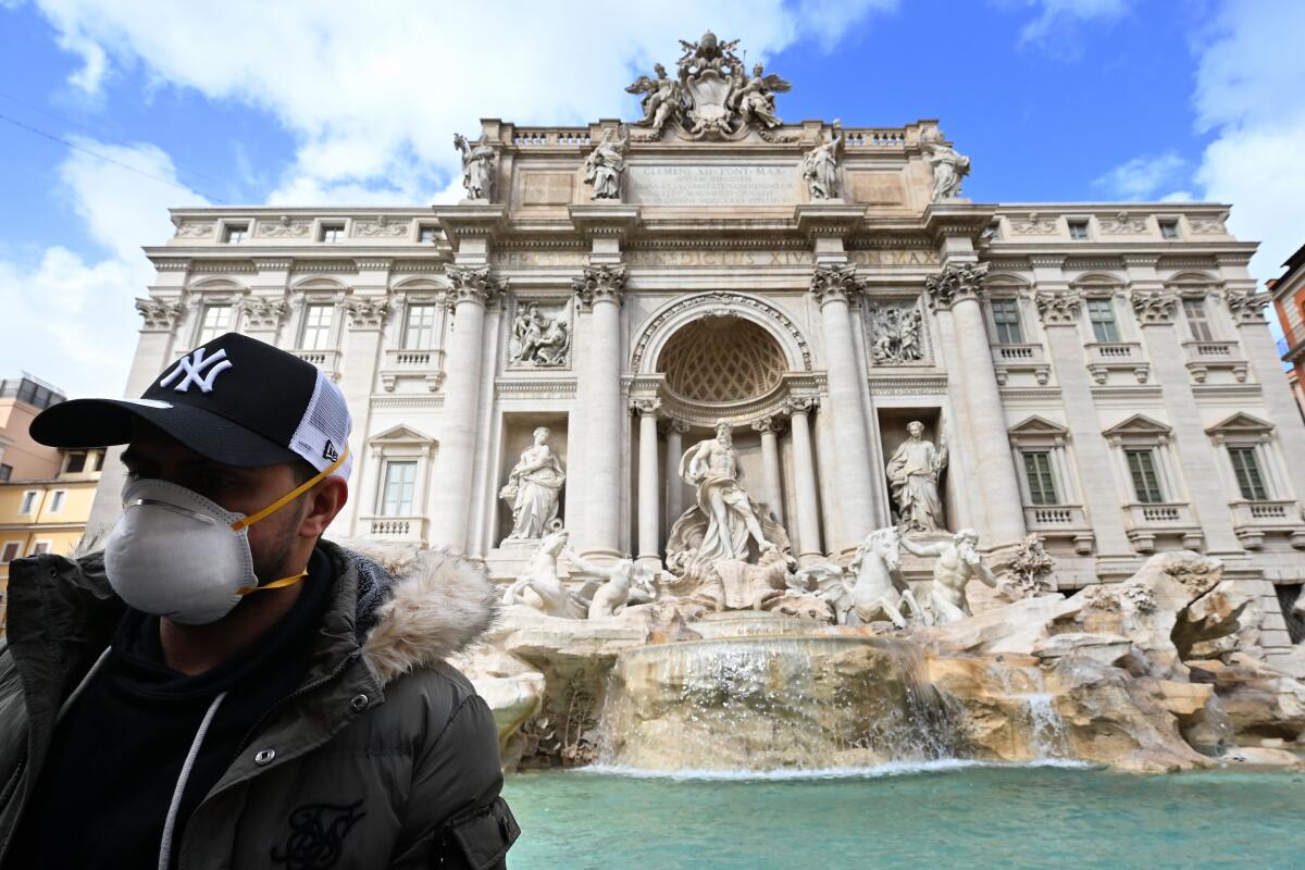 A masked tourist at Rome's Trevi Fountain