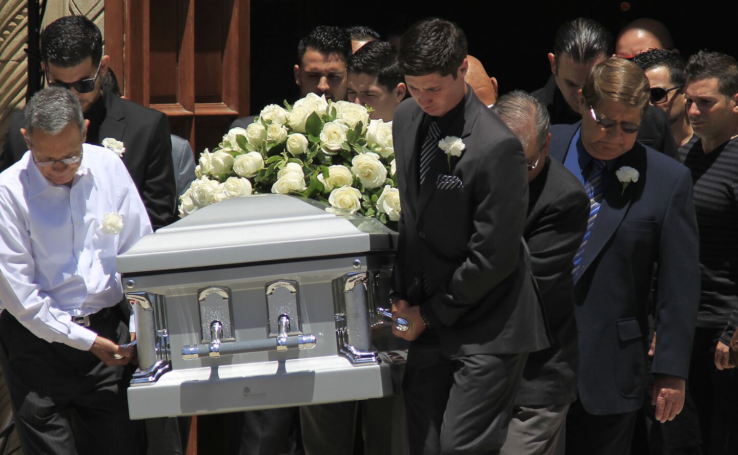 Pallbearers carry the casket of Carlos Franco following a funeral mass for Marcela and Carlos Franco at Saint Monica's Catholic Church.