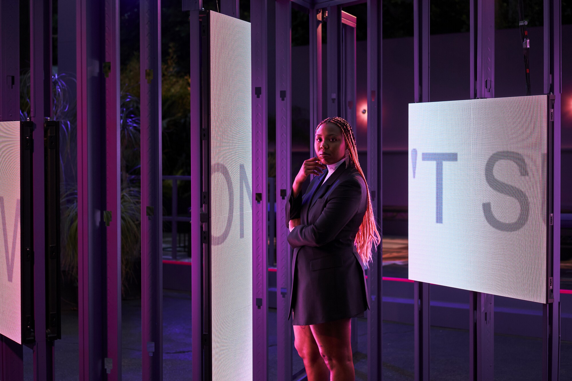 What does it mean to be truly alive in L.A.? Martine Syms is using film to figure out - Los Angeles Times 2 A woman with pink braids stands in front of screens projecting letters