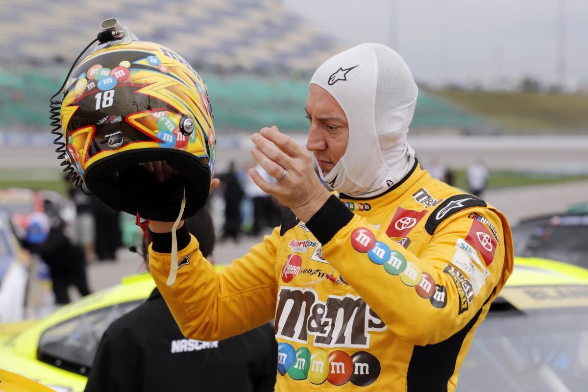Kyle Busch removes his helmet after making a run during qualifying for a NASCAR Cup Series auto race at Kansas Speedway in Kansas City, Kan., Saturday, Sept. 10, 2022. (AP Photo/Colin E. Braley)