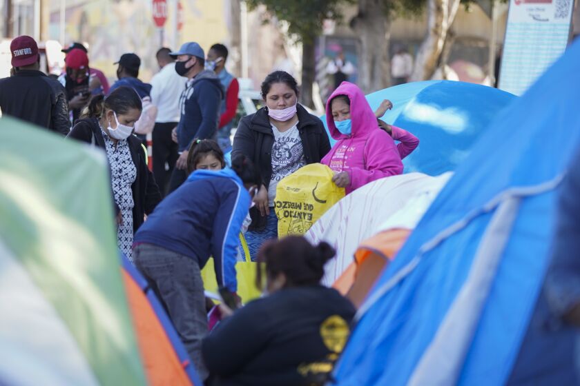 Tijuana, Baja California - February 24: Asylum seekers have set up tents as they settle in at El Chaparral port of entry on Wednesday, Feb. 24, 2021 in Tijuana, Baja California. Hundreds wait in the area. A group of women go over donations. (Alejandro Tamayo / The San Diego Union-Tribune)