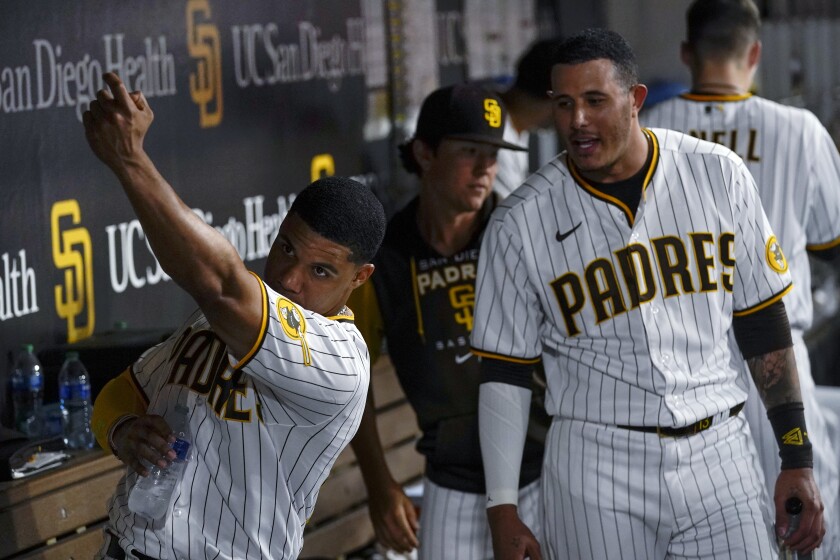 Juan Soto, left, and Manny Machado talk in the Padres dugout 