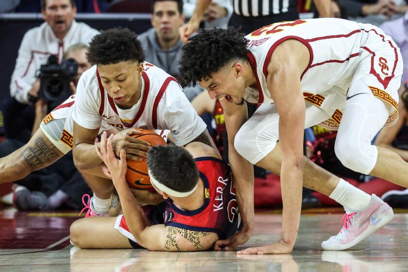 Los Angeles, CA, Tuesday, March 1, 2022 - USC Trojans guard Boogie Ellis (0) and USC Trojans forward Max Agbonkpolo (23) wrestle for the ball with Arizona Wildcats guard Kerr Kriisa (25) at the Galen Center. (Robert Gauthier/Los Angeles Times)
