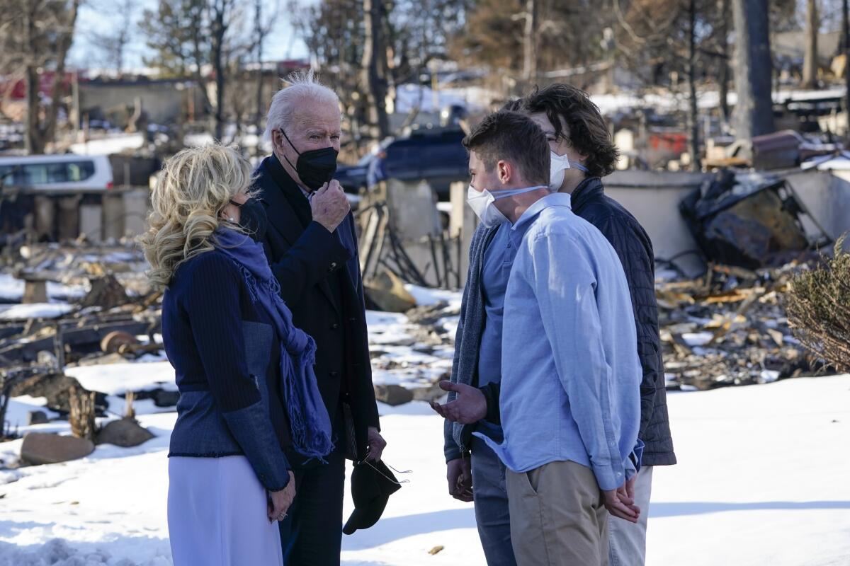 President Biden and wife Jill talk with people in a snowy landscape