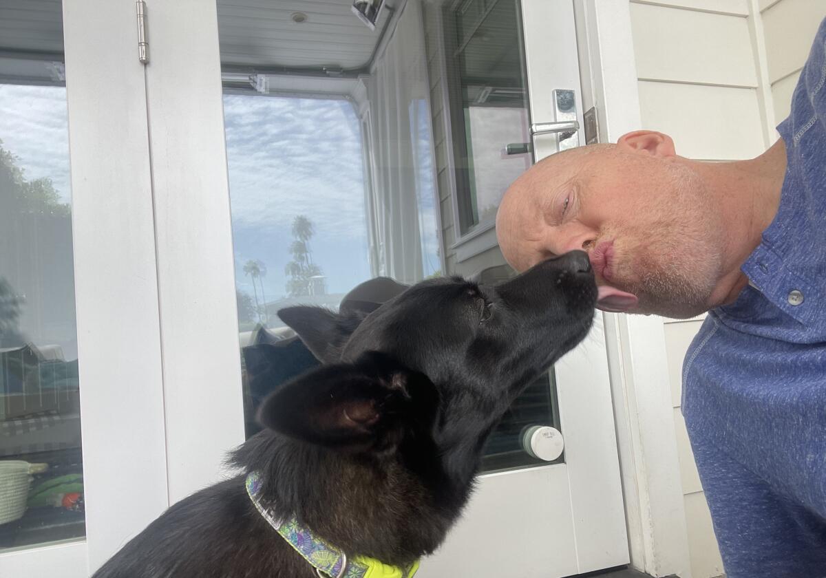 UCLA coach Mick Cronin plays with his dog, Bookster, at his home. 