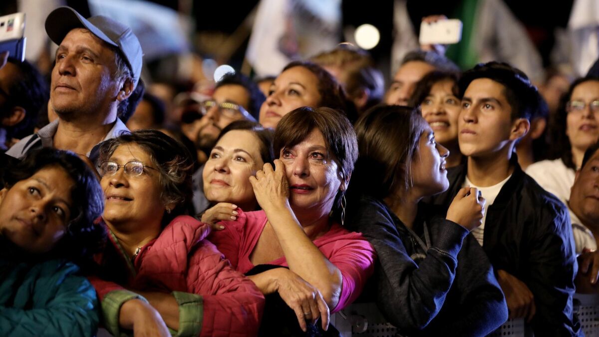 A woman weeps while supporters of Andres Manuel Lopez Obrador wait for his arrival in the Zocalo in Mexico City on July 1, 2018.