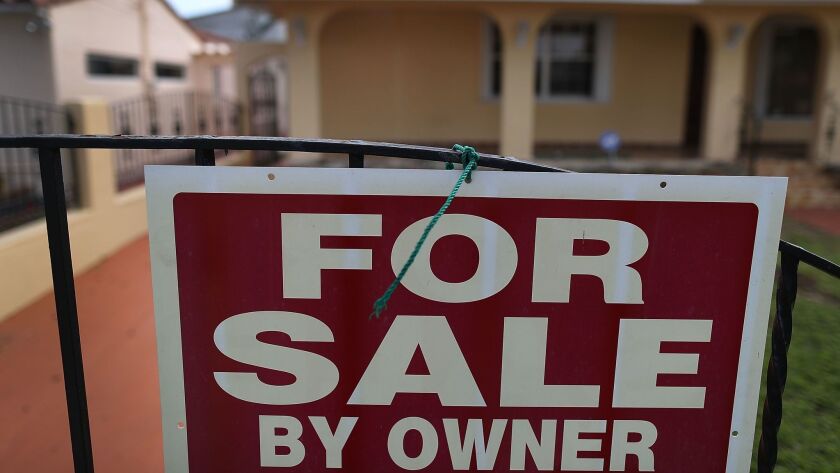 A For Sale sign is posted in front of a home in Miami, Fla.