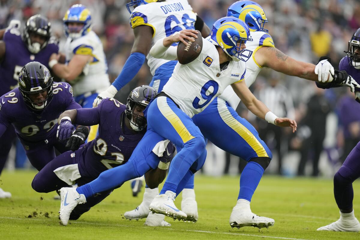 Rams quarterback Matthew Stafford eludes Baltimore Ravens defensive tackle Justin Madubuike and linebacker Odafe Oweh.