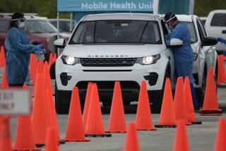 Healthcare workers administer nasal swabs to drivers and passengers at a drive-through COVID-19 testing site at Zoo Miami, Monday, Jan. 3, 2022, in Miami. (AP Photo/Rebecca Blackwell)