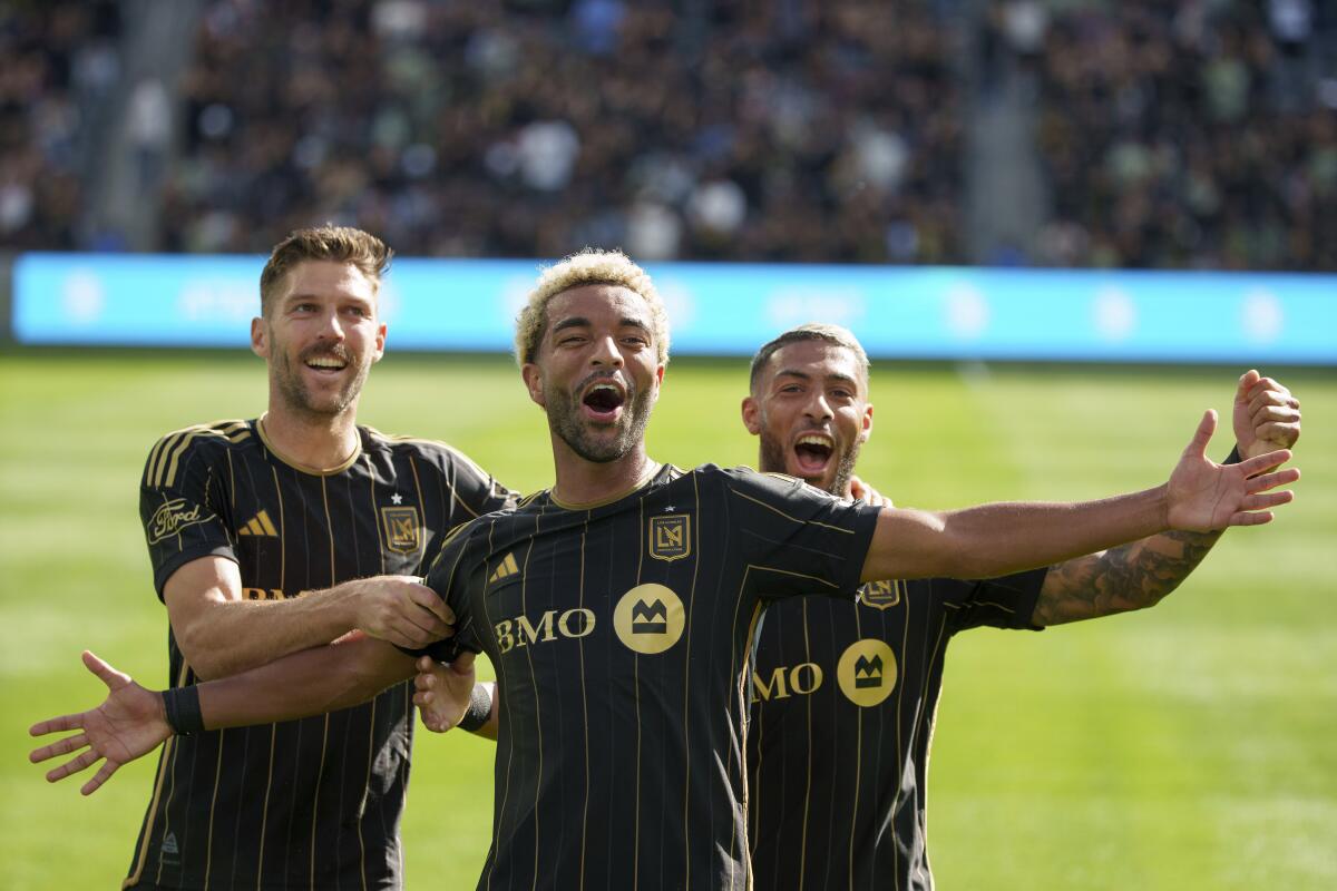 LAFC midfielders Ryan Hollingshead, left, and Timothy Tillman, center, and forward Denis Bouanga celebrate a goal.