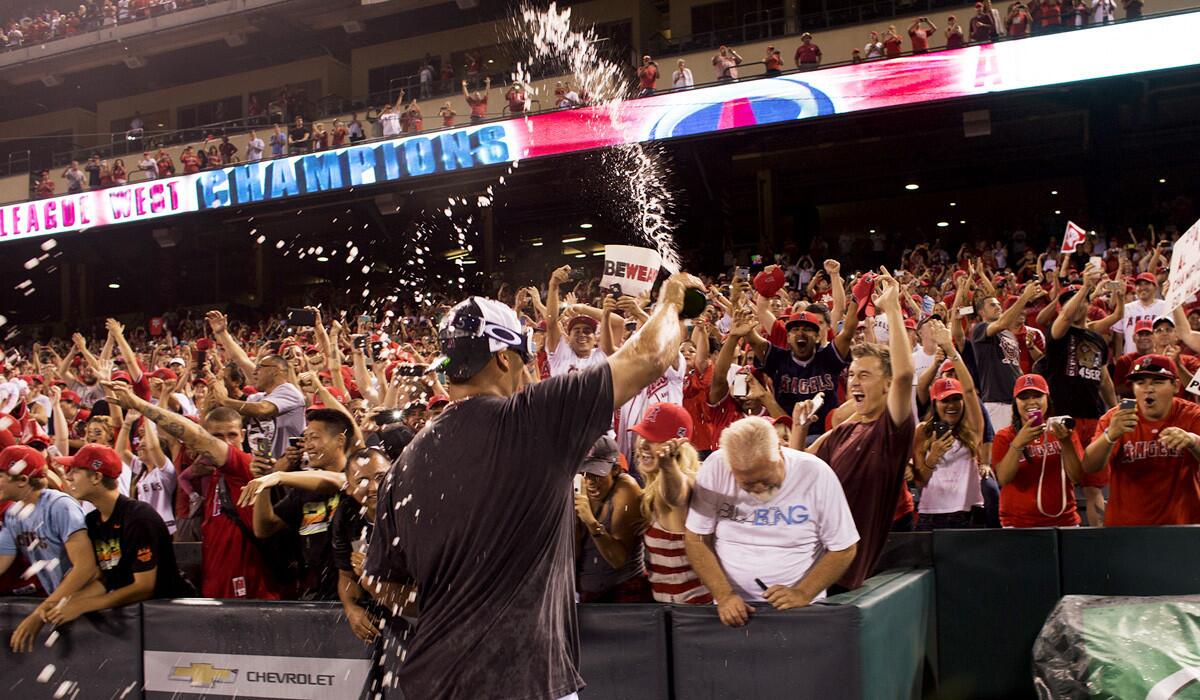 Angels first baseman Albert Pujols celebrates with fans after the Angels clinched the American League West title on Wednesday night.