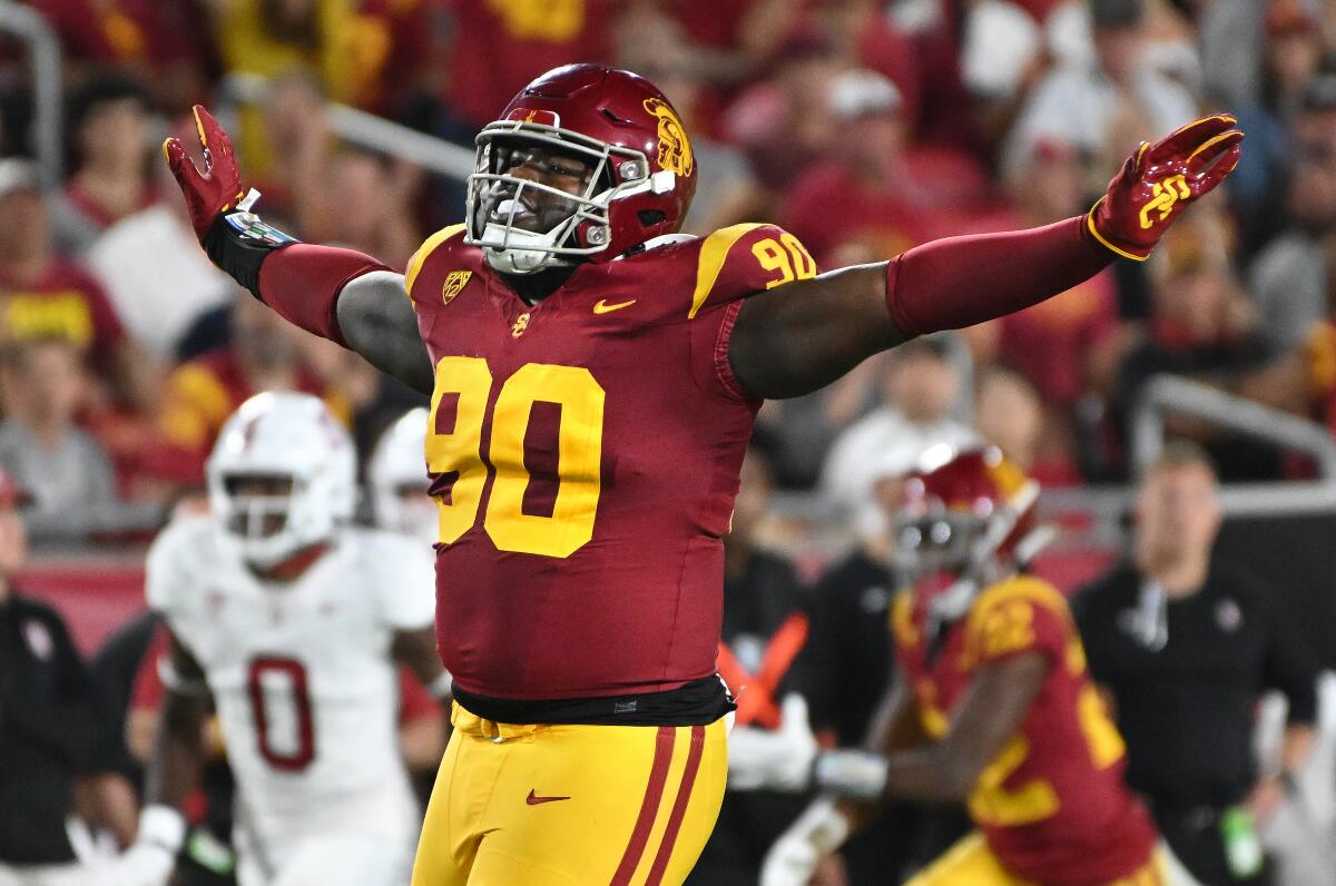 USC defensive lineman Bear Alexander celebrates after tipping a Stanford pass during a game at the Coliseum 
