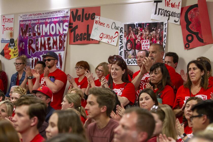 Teachers, students and others pack the Huntington Beach Union High School District board meeting Tuesday night to call on the district to reach an agreement with the teachers union on the union’s two-year contract proposal and to demand greater transparency in negotiations and district funds.