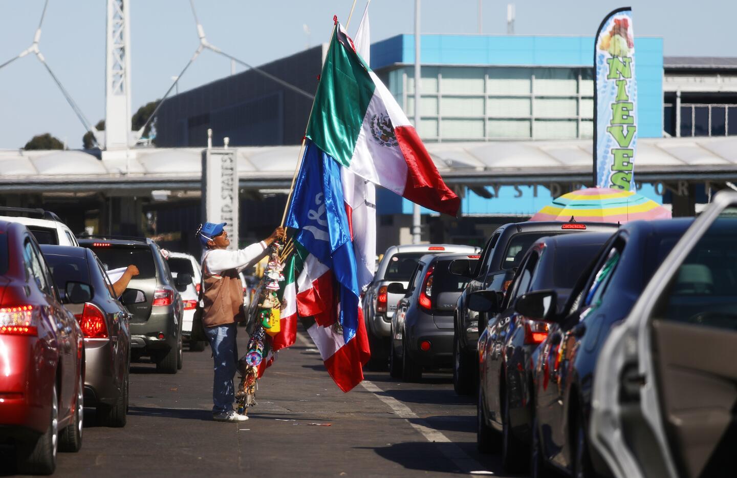 A man sells Mexican flags and other items as cars line up to cross into the United States at the San Ysidro Port of Entry, one of the busiest land border crossings in the world, on the U.S.-Mexico border on March 31, 2019 in Tijuana, Mexico.