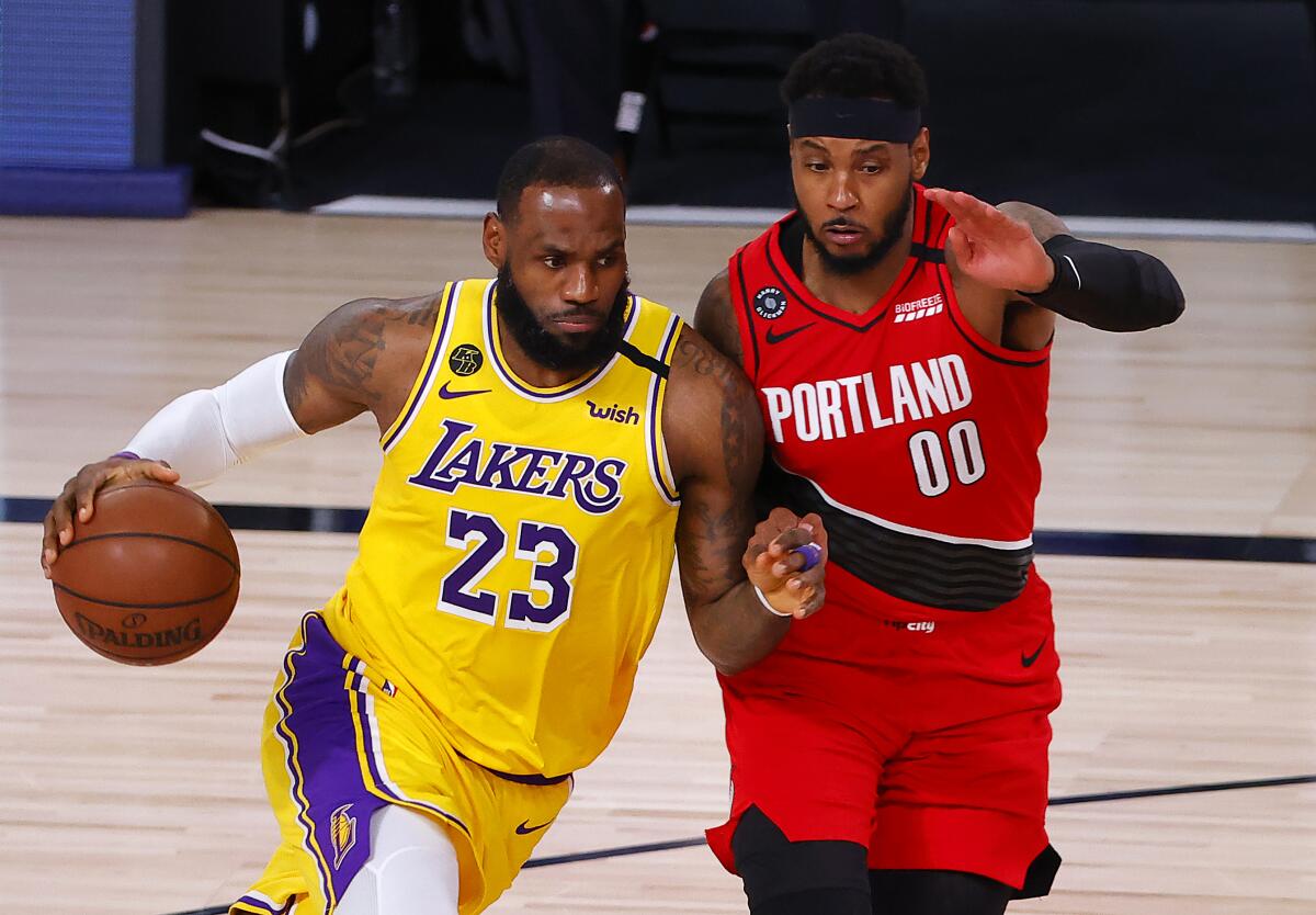 Lakers forward LeBron James drives against Portland Trail Blazers forward Carmelo Anthony.