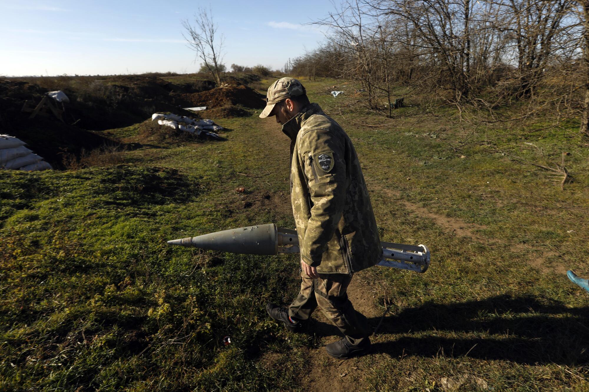 A member of the Ukrainian Special Forces holds a Russian missile cassette that carried cluster bombs. 