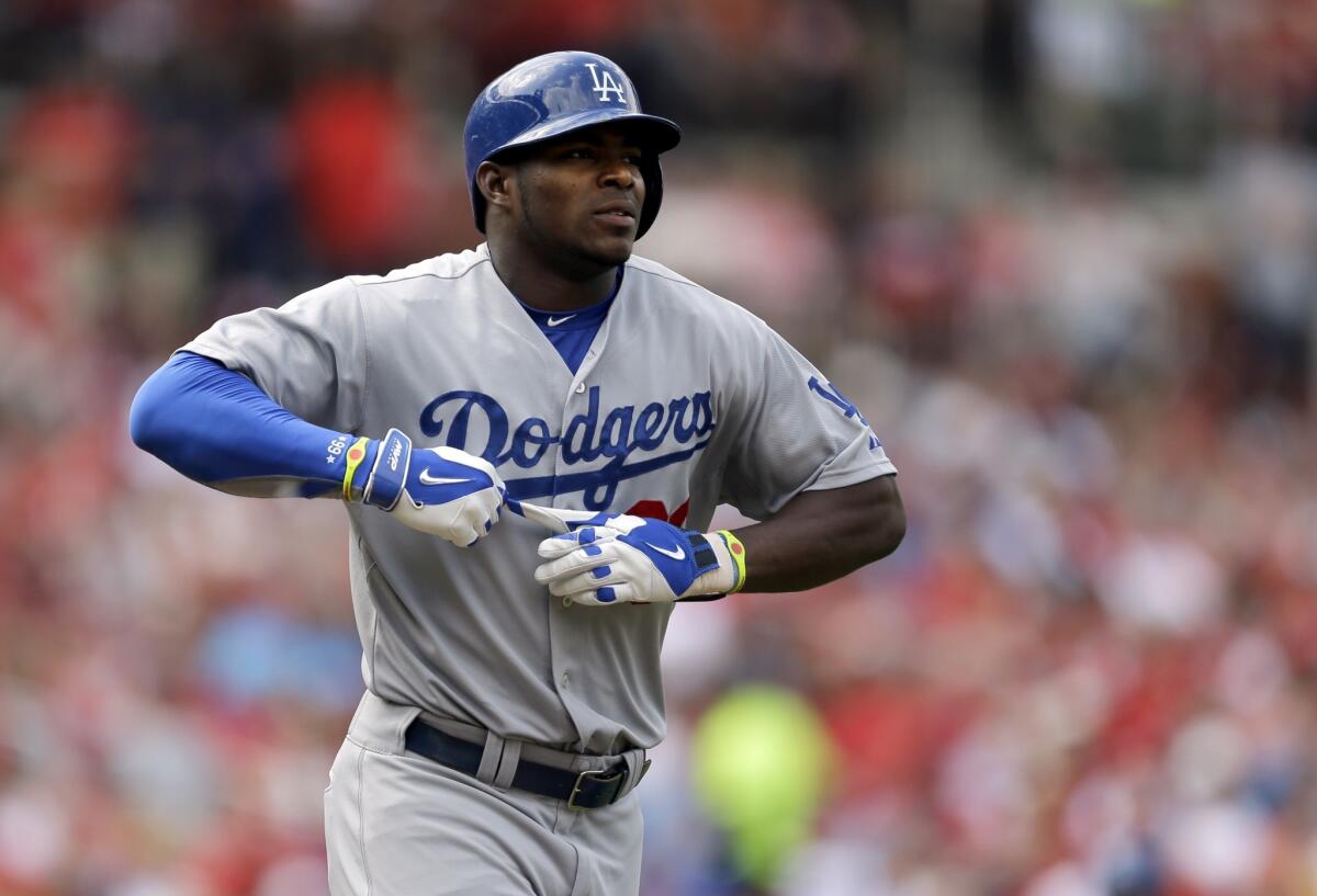 Yasiel Puig pulls a glove off his left hand as he takes his base after being hit by a pitch from St. Louis' Joe Kelly during the third inning. The Dodgers fell to the Cardinals, 4-2.