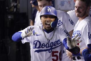 Los Angeles Dodgers' Mookie Betts celebrates in the dugout after hitting a solo home run.