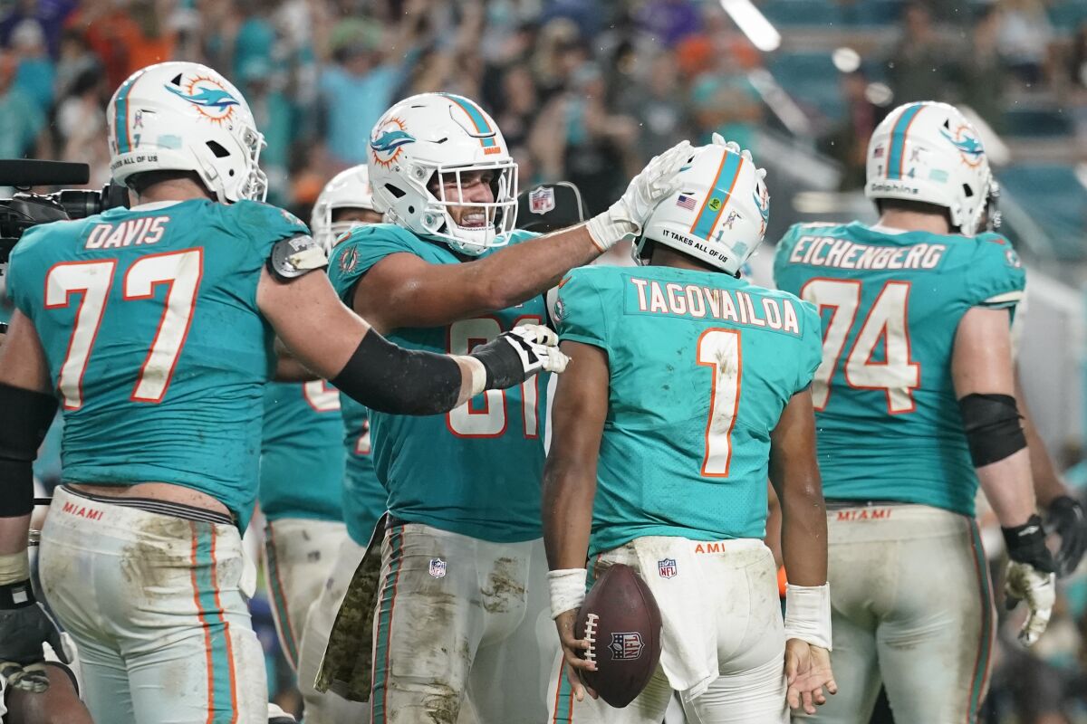 Miami Dolphins tight end Durham Smythe (81) celebrates with Miami Dolphins quarterback Tua Tagovailoa (1) after Tagovailoa scored a touchdown during the second half of an NFL football game against the Baltimore Ravens, Thursday, Nov. 11, 2021, in Miami Gardens, Fla. The Dolphins defeated the Ravens 22-10.(AP Photo/Lynne Sladky)