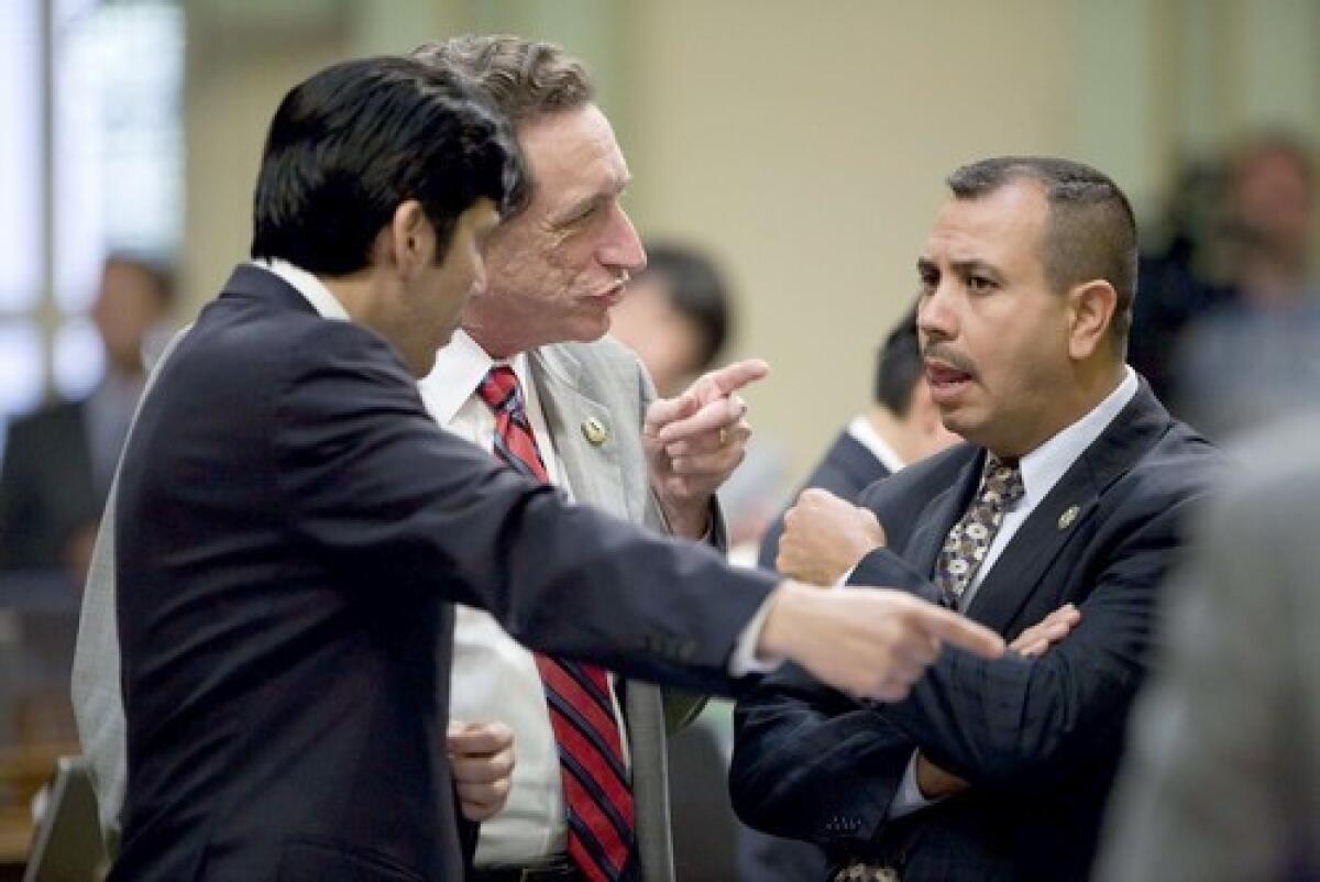 Assemblymen Kevin de Leon (D-Los Angeles), Ira Ruskin (D-Redwood City) and Tony Mendoza (D-Artesia), from left, discuss a bill during Fridays budget deliberations in Sacramento.