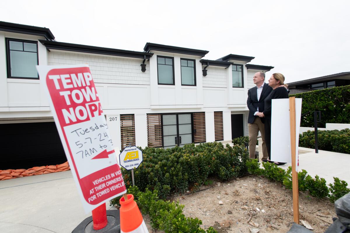 Amy and Marshall Senk stand outside of their newly rebuilt home Friday.