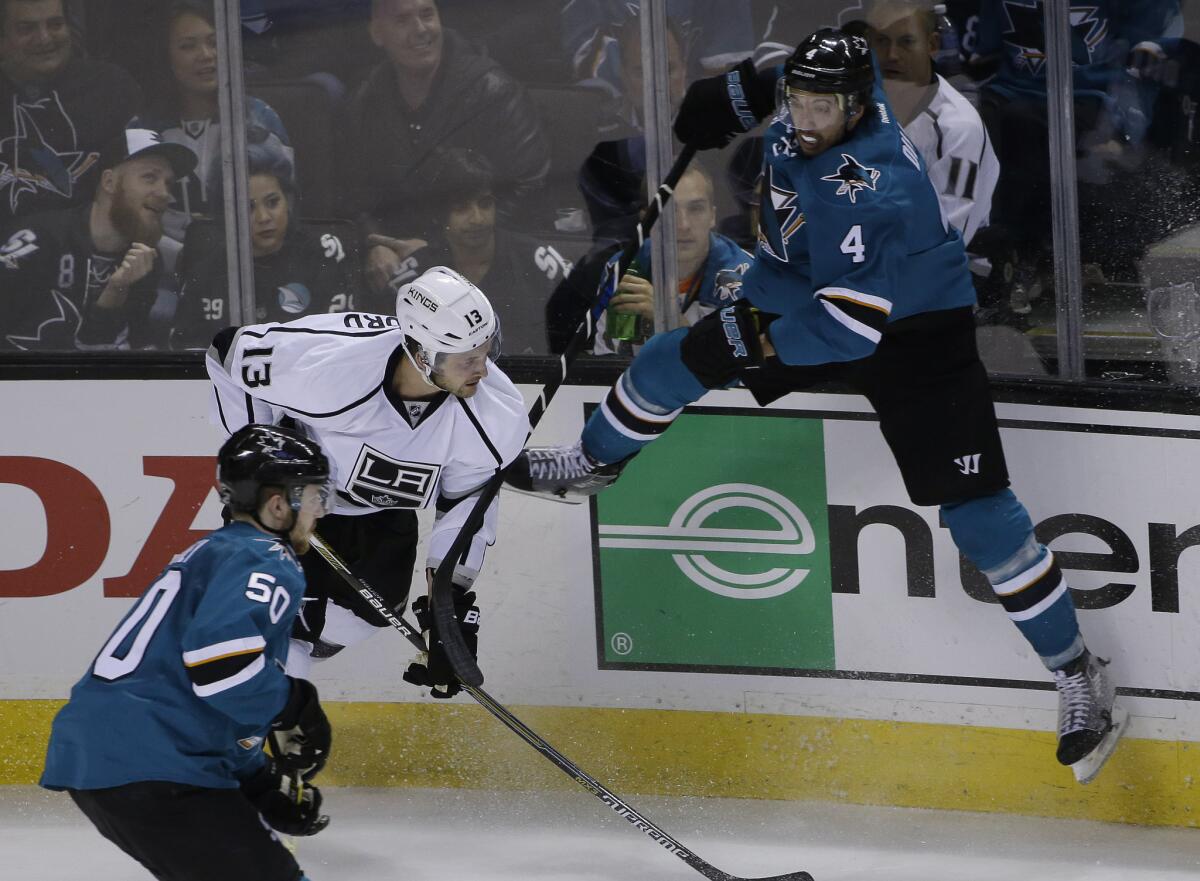 San Jose's Brenden Dillon leaps next to the Kings' Kyle Clifford during Monday's game.