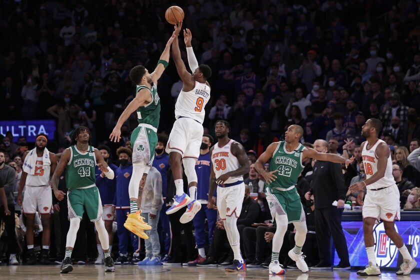 New York Knicks guard RJ Barrett (9) makes the game-winning 3-point basket in front of Boston Celtics forward Jayson Tatum during an NBA basketball game Thursday, Jan. 6, 2022, in New York. The Knicks won 108-105. (AP Photo/Adam Hunger)