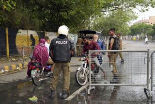 Pakistani security officials close a road outside the former Prime Minister Imran Khan's residence in Lahore, Pakistan, Thursday, May 18, 2023. Pakistani police kept up their siege around the home of Khan as a 24-hour deadline given to the former premier to hand over suspects allegedly sheltered inside was about to expire on Thursday. (AP Photo/K.M. Chaudary)