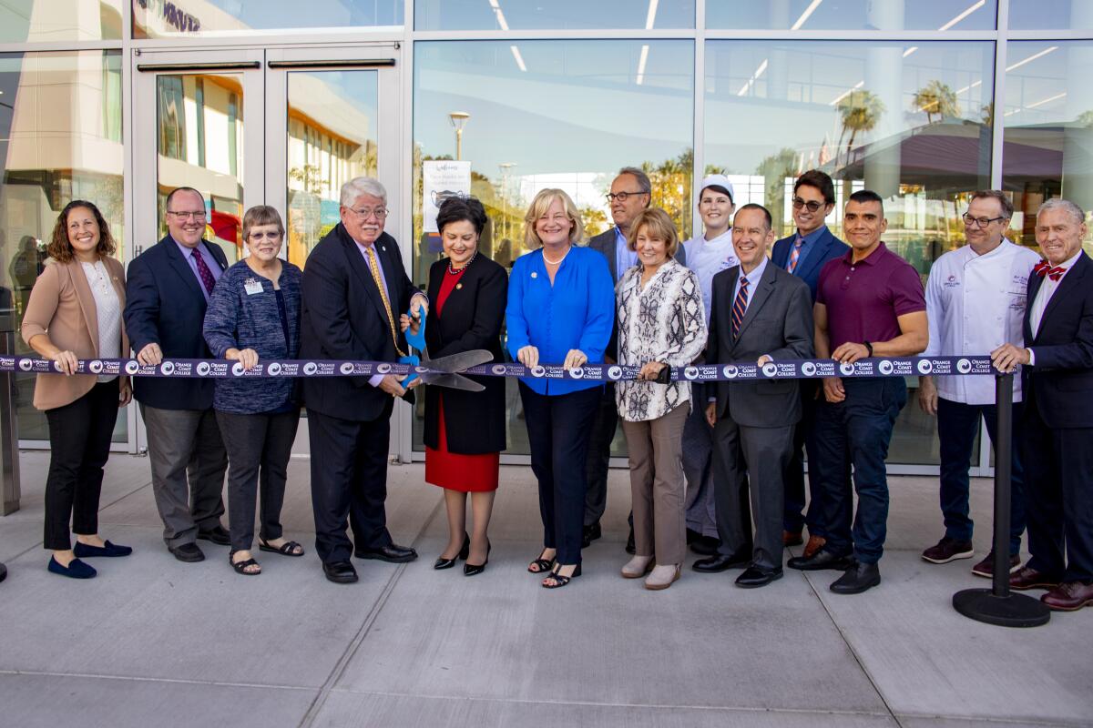 Coast Community College District Board of Trustees President Jim Moreno prepares to cut the ribbon.  