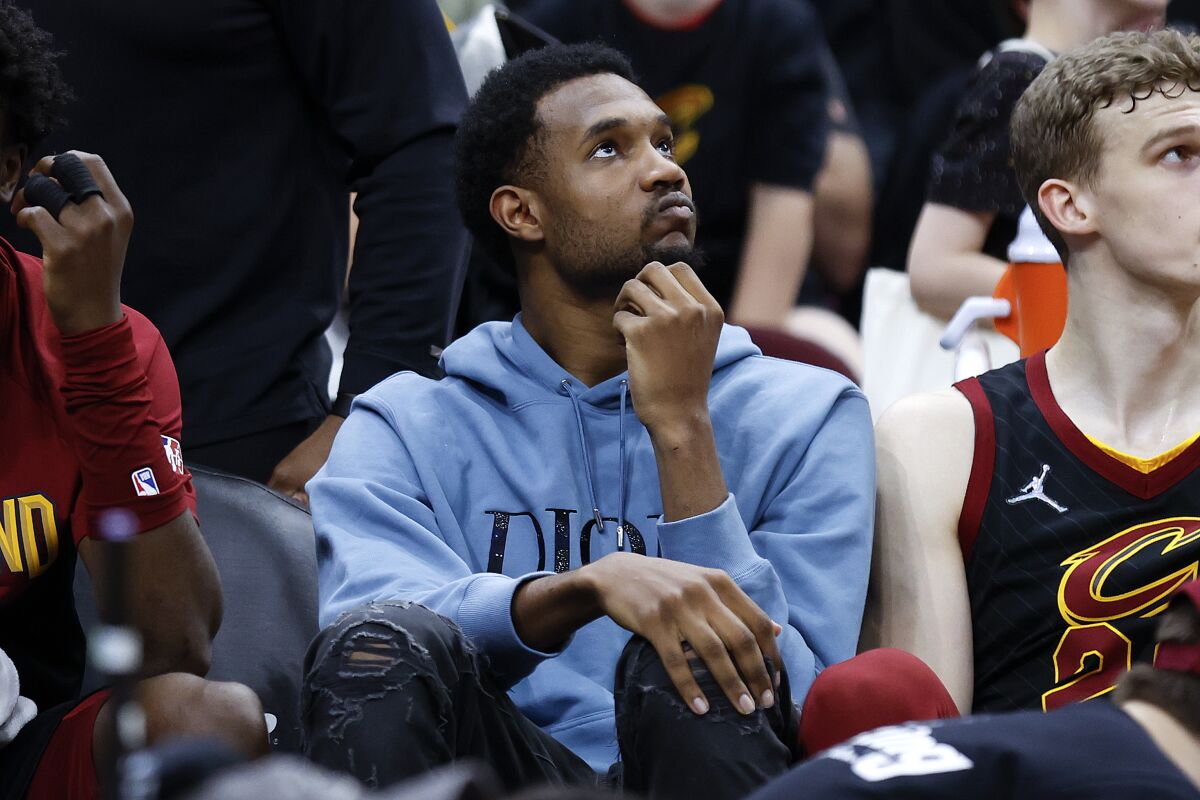 Injured Cleveland Cavaliers center Evan Mobley watches from the bench during the second half of the team's NBA basketball game against the Dallas Mavericks, Wednesday, March 30, 2022, in Cleveland. (AP Photo/Ron Schwane)