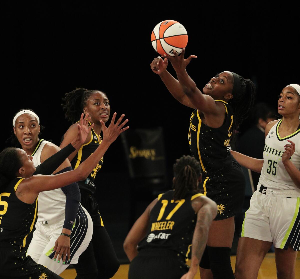 The Sparks' Chiney Ogwumike grabs a defensive rebound in front of the Dallas Wings' Charli Collier on May 14, 2021.