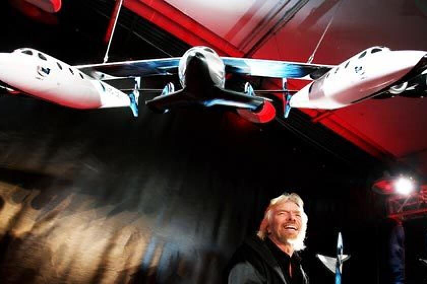 Richard Branson of Virgin Atlantic stands under a model of a spaceship unveiled today in New York City. He hopes the aircraft will be the first to ferry paying passengers into space on a regular basis. Branson's Virgin Galactic is one of several commercial enterprises currently competing to offer flights to space.