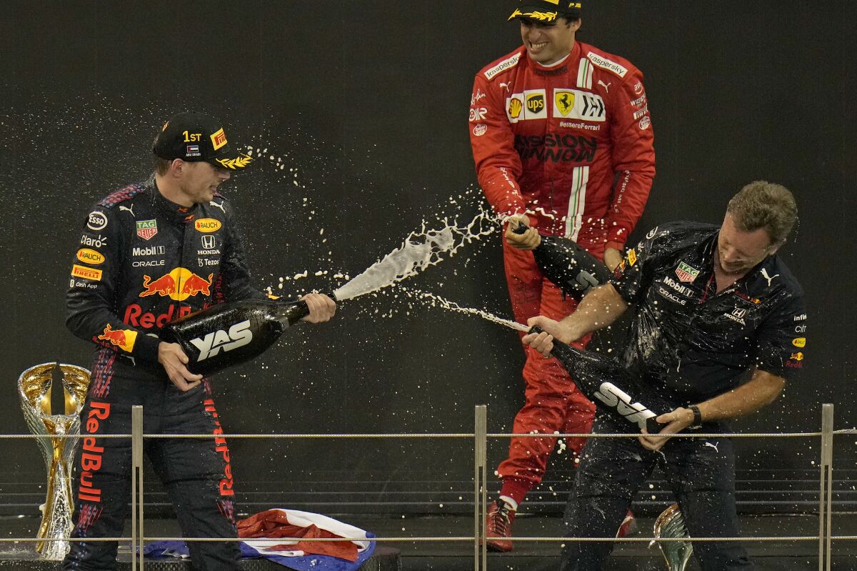Red Bull team chief Christian Horner, right, celebrates with his driver Max Verstappen of the Netherlands after winning the Formula One Abu Dhabi Grand Prix in Abu Dhabi, United Arab Emirates, Sunday, Dec. 12, 2021. Max Verstappen ripped a record eighth title away from Lewis Hamilton with a pass on the final lap of the Abu Dhabi GP to close one of the most thrilling Formula One seasons in years as the first Dutch world champion. (AP Photo/Hassan Ammar)