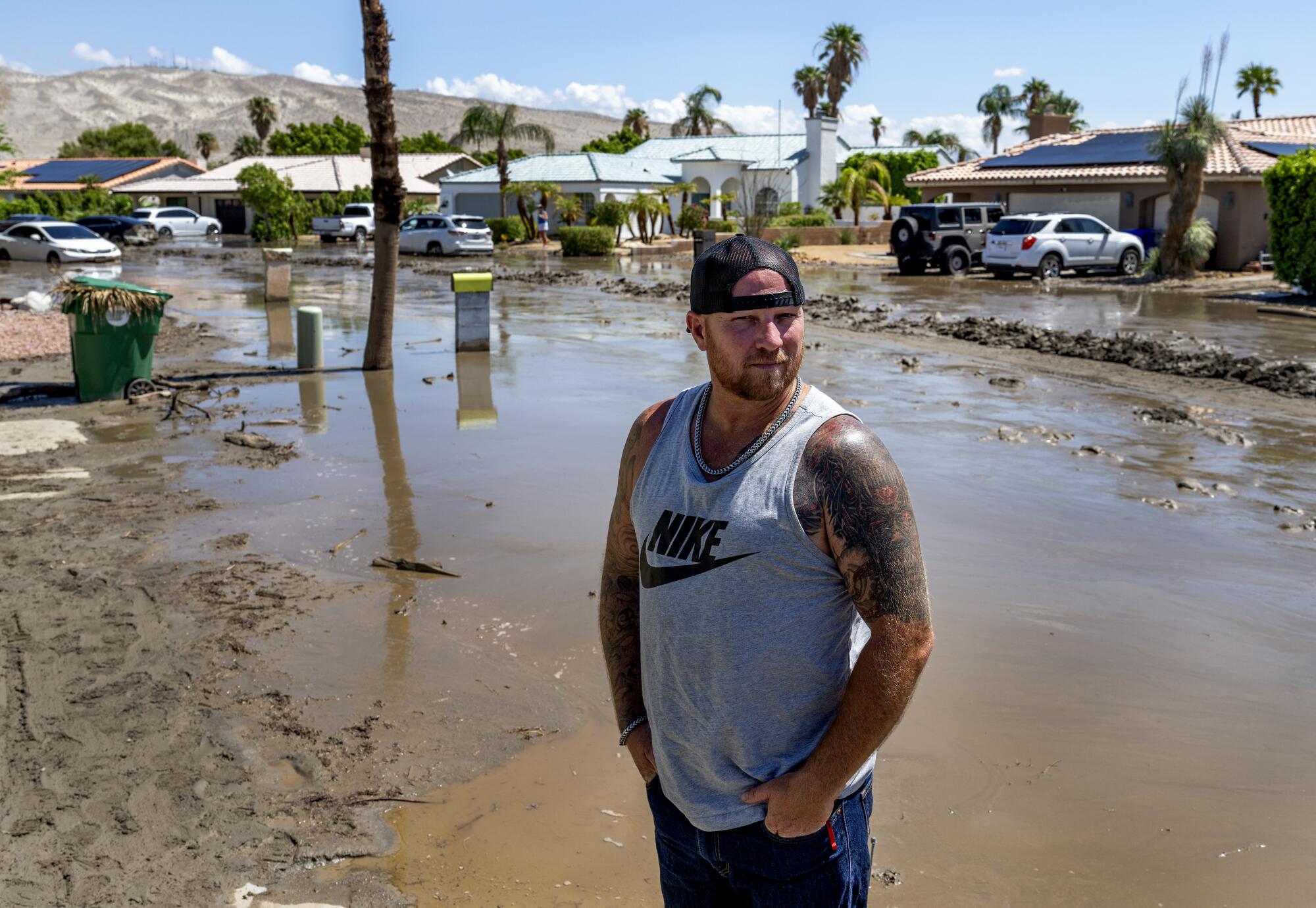 A man stands before a flooded street