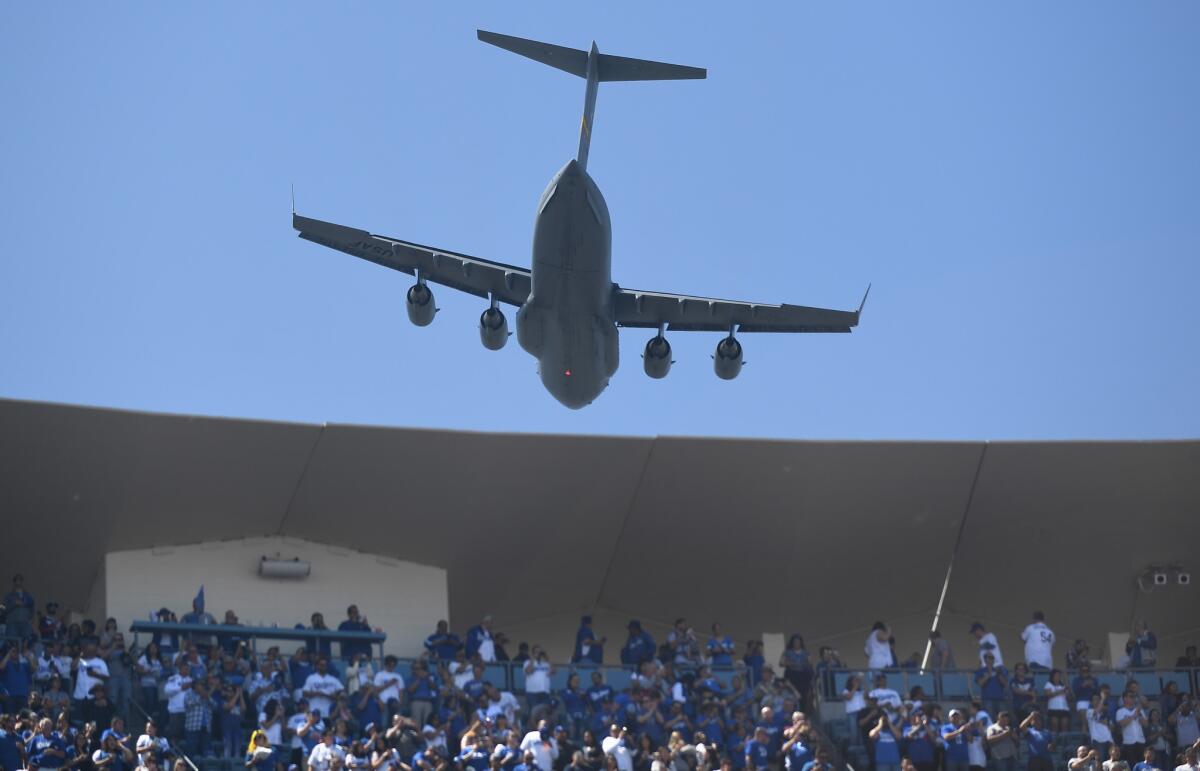 A C-17 Globemaster military transport plane flies over Dodger Stadium during opening day festivities on Thursday.