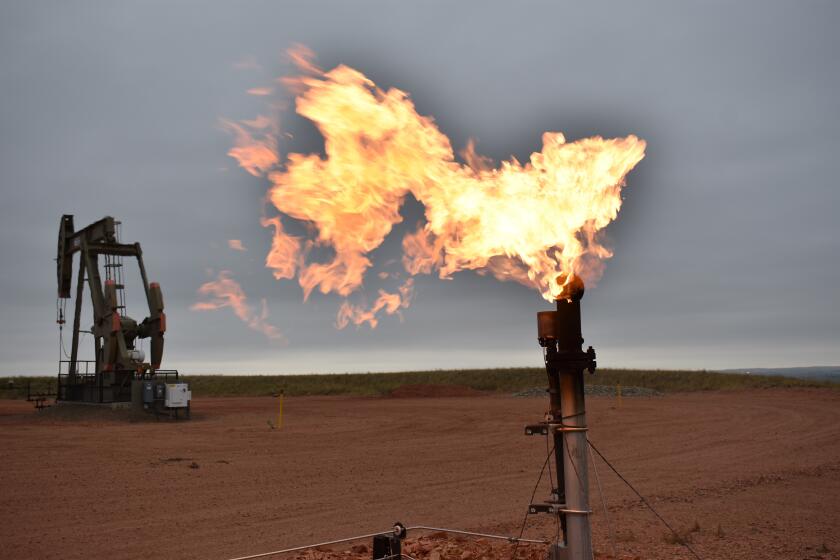 FILE - A flare burns natural gas at an oil well on Aug. 26, 2021, in Watford City, N.D. A new federal report released Friday, Oct. 29, 2021, says fossil fuel extraction from federal lands produced more than 1 billion tons (918 million metric tons) of greenhouse gases last year. (AP Photo/Matthew Brown, File)