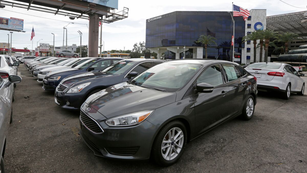 Used cars sit at an auto dealership in Miami.